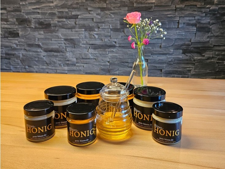 Mehrere Honiggläser auf einem Tisch
