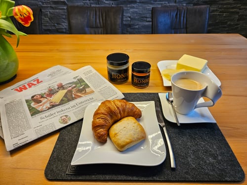 Honigglas und WAZ auf dem Frühstückstisch